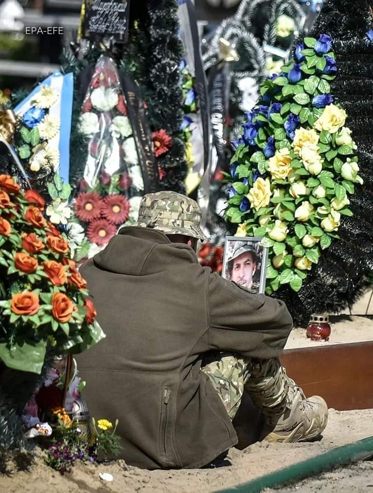 ภาพของวันนี้: ทหารคนหนึ่งนั่งอยู่ใกล้หลุมศพของสหายที่เสียชีวิตในซอยแห่งวีรบุรุษ
